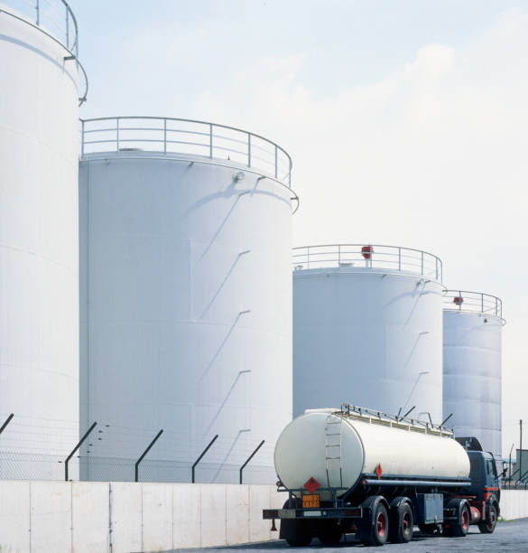 road tanker in front of oil refinery tanks, neutral with copy space